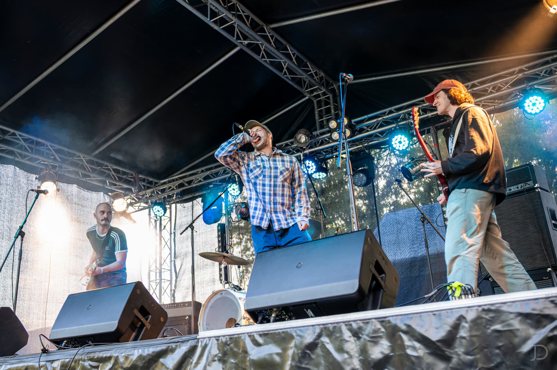 Kapela hrající na festivalovém pódiu v protisvětle